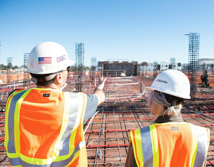 Two workers in high-visibility safety vests on a construction site