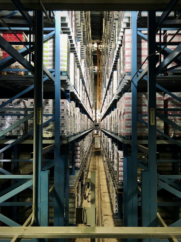Aisle of tall warehouse racking stacked with boxes